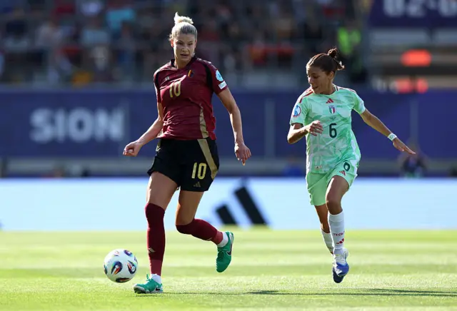 Justine Vanhaevermaet runs with the ball under pressure from Manuela Giugliano