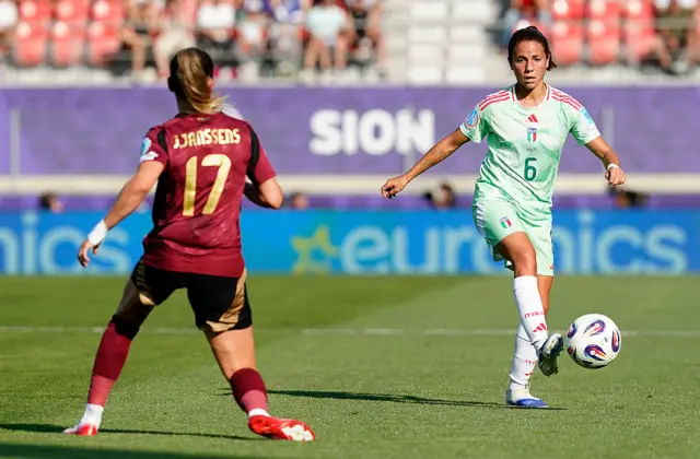 Manuela Giugliano passes the ball under pressure from Jill Janssens