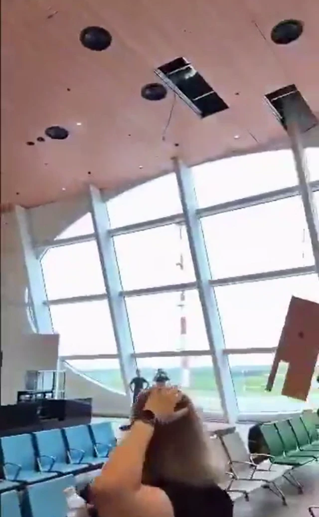 Still taken from a video featuring a woman sitting in an airport