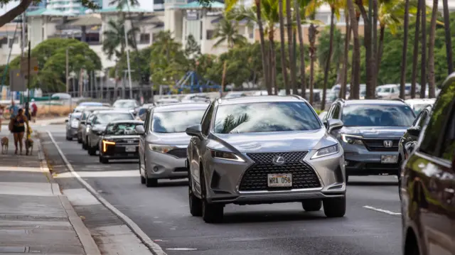 Cars leave Waikiki beach in Hawaii.