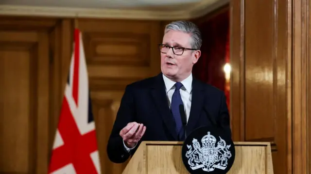 UK Prime Minister Sir Keir Starmer standing at a lectern in front of a union flag