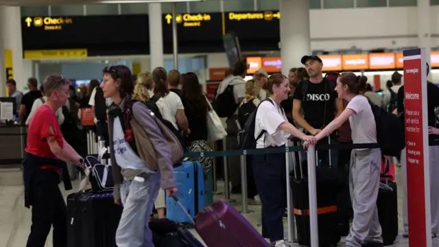 Passengers queue at Gatwick Airport in UK.