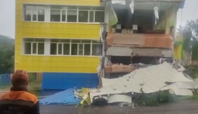 A yellow building with three storeys heavily damaged