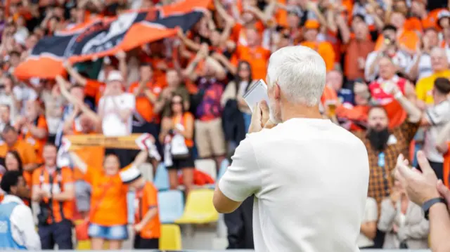 Dundee United manager Jim Goodwin greets the travelling fans