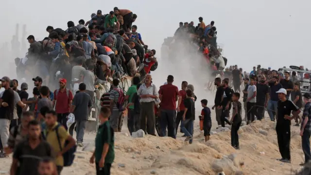 Palestinians climb onto trucks carrying aid supplies that entered Gaza through Israel