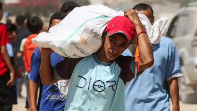 Palestinians collect aid parcels that were airdropped, amid a hunger crisis, in Zawayda, in the central Gaza Strip