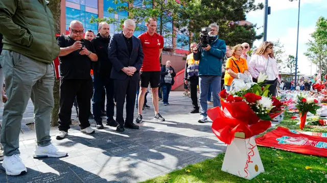 Chris Kirkland and Liverpool club chaplain Bill Bygroves lay flowers in tribute to Diogo Jota and his brother André Silva outside Anfield.