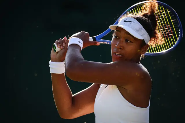 Naomi Osaka swings a tennis racquet