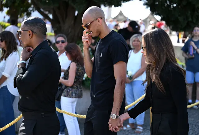Fabinho, in black, holding hands with his partner