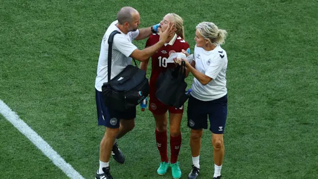 Denmark's Pernille Harder receives medical attention after sustaining an injury