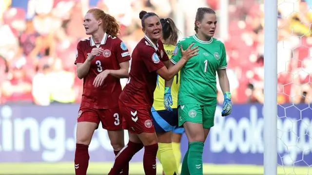 Maja Bay Oestergaard of Denmark is congratulated by teammate Katrine Veje, as Stine Ballisager Pedersen of Denmark looks on during the UEFA Women's EURO 2025 Group C match between Denmark and Sweden