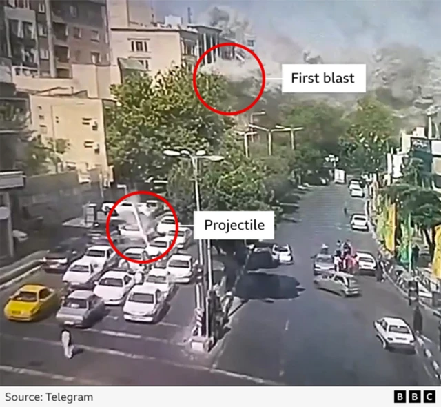 Screengrab from a recording of CCTV footage showing a projectile about to make impact in the foreground and in the background another explosion in Tehran, Iran on 15 June