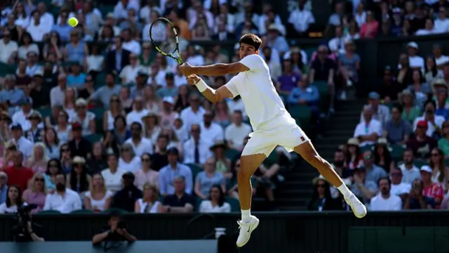 Carlos Alcaraz jumps as he plays a backhand
