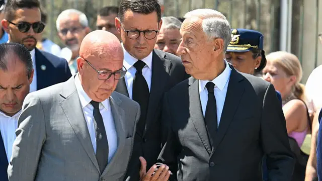 Portuguese president Marcelo Rebelo de Sousa (R) walks surrounded by official and security as he attends Diogo Jota's wake in Gondomar