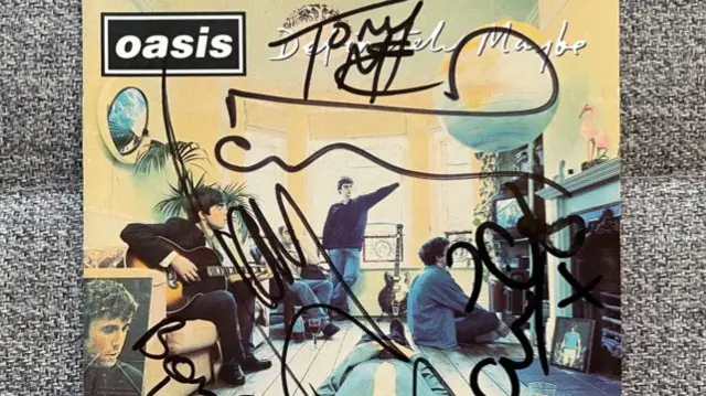 A signed album of Oasis Definitely Maybe