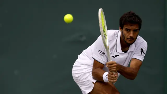 Francisco Cabral mid-play during the men's doubles at Wimbledon wears a black ribbon to mark Diogo Jota's death