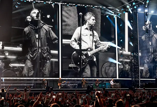 Oasis band pictured up on stage at the Principality stadium.