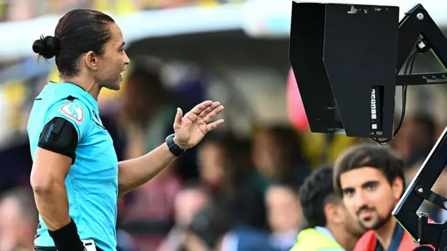 Brazilian Edina Alves consults the VAR during the UEFA Women's Euro 2025 Group C football match between Denmark and Sweden at the Stade de Geneve in Geneva