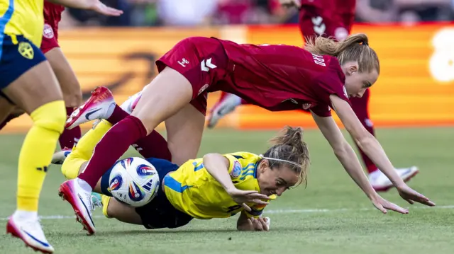 Sweden's Kosovare Asllani (bottom) and Denmark's Karen Holmgaard in action during the UEFA Women's EURO 2025 group stage soccer match of Denmark against Sweden,