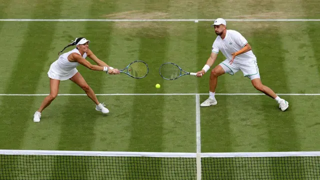 Giuliana Olmos reaches to play a backhand with Lloyd Glasspool