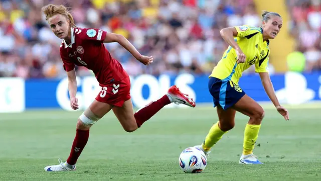 Karen Holmgaard of Denmark and Filippa Angeldal of Sweden looks on towards a loose ball during the UEFA Women's EURO 2025 Group C match between Denmark and Sweden at Stade de Geneve