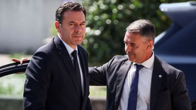 Portugal's Prime Minister Luis Montenegro in a suit walking out of a car