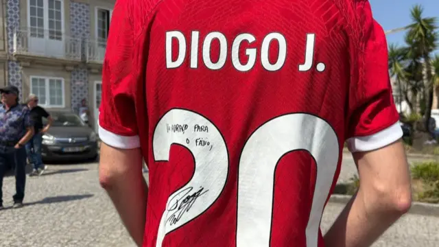 The back of a man wearing a Liverpool shirt with the number 20, signed by Diogo Jota