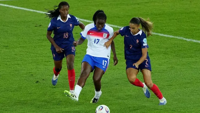 Michelle Agyemang of England passes the ball under pressure from Oriane Jean-Francois and Maelle Lakrar of France during the UEFA Women's EURO 2025 Group D match between France and England