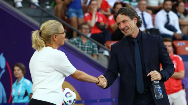 England manager Sarina Wiegman shakes hands with France coach Laurent Bonadei before the match