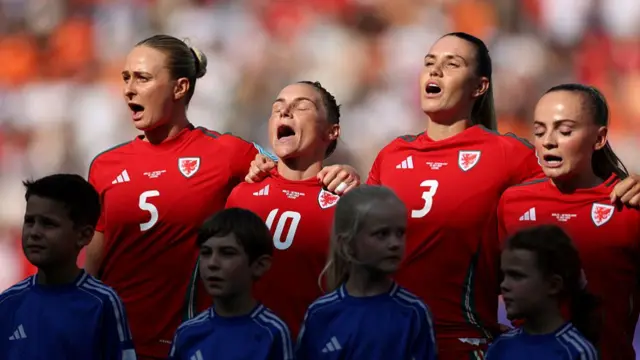 Rhiannon Roberts, Jess Fishlock and Gemma Evans sing the national anthem prior to the UEFA Women's EURO 2025 Group D match between Wales and Netherlands at Luzern Arena
