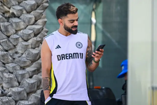 Virat Kohli texting on his phone