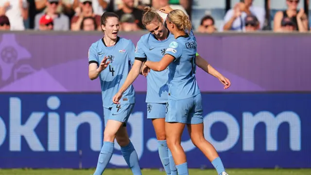 Vivianne Miedema of the Netherlands celebrates scoring her team's first goal with teammates Veerle Buurman, and Kerstin Casparij, marking her 100th goal for the Netherlands, during the UEFA Women's EURO 2025 Group D match between Wales and Netherlands