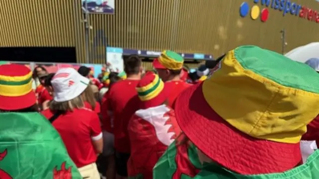 Wales fans wearing bucket hats outside the stadium