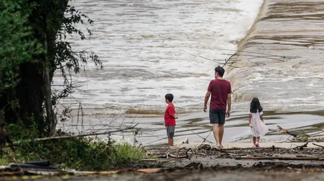 People watch the Guadalupe River flow over a bridge in Kerrville, Texas, USA 05 July 2025.