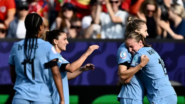 Netherlands' forward #09 Vivianne Miedema (2nd L) is hugged by Netherlands' midfielder #19 Wieke Kaptein as she celebrates scoring the team's first goal during the UEFA Women's Euro 2025 Group D football match between Wales and The Netherlands