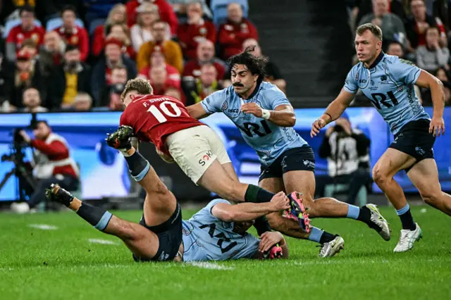 Waratahs' Ethan Dobbins (bottom) and Charlie Gamble (2R) tackles British and Irish Lions' Fin Smith
