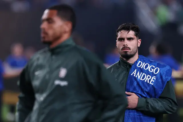 Neto (R) holds a shirt to pay tribute to Liverpool's Portuguese forward Diogo Jota and his brother Andre Silva