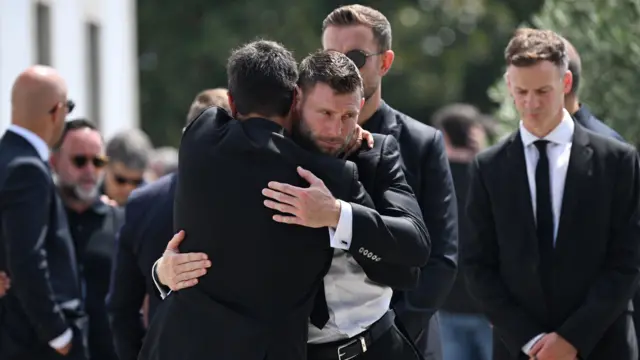 James Milner hugs a mourner