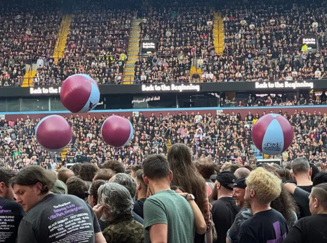 Some beach balls are in the air above the crowd.