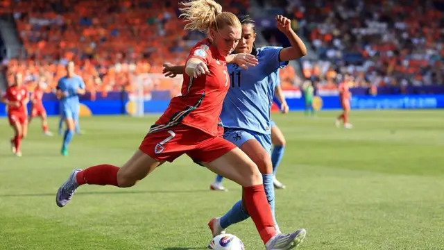 Ceri Holland of Wales passes the ball under pressure from Esmee Brugts of the Netherlands during the UEFA Women's EURO 2025 Group D match between Wales and Netherlands at Luzern Arena