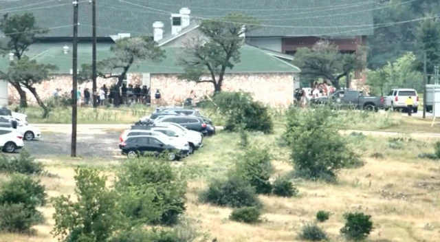 Cars and people surrounding a building