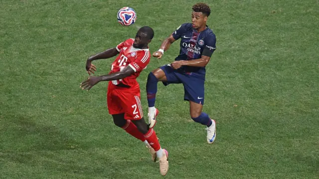 Dayot Upamecano of FC Bayern Munchen battles for possession with Desire Doue