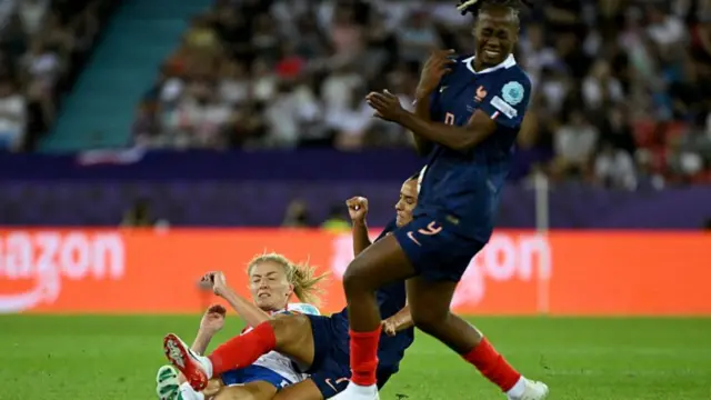 England's defender #06 Leah Williamson (L) and France's midfielder #07 Sakina Karchaoui (C) fall to the ground as France's forward #09 Melvine Malard avoids falling too during the UEFA Women's Euro 2025 Group D football match between France and England