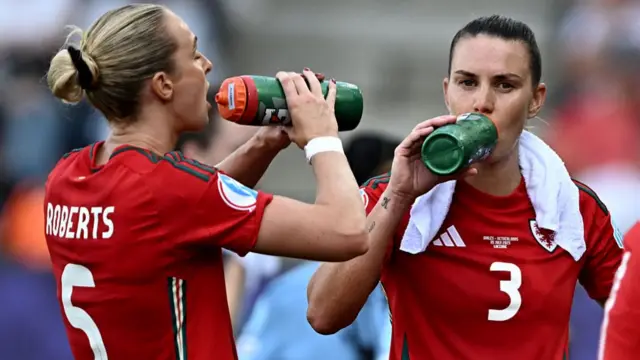 Wales' defender #03 Gemma Evans (R) and Wales' defender #05 Rhiannon Roberts hydrate during the UEFA Women's Euro 2025 Group D football match between Wales and The Netherlands