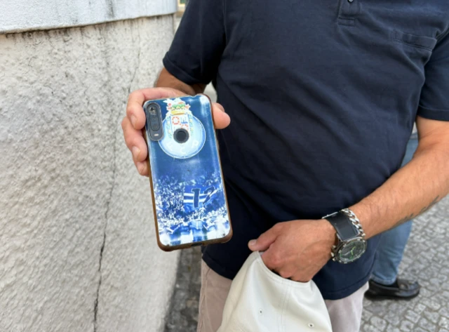 Antonio Moreira holding his phone to the camera, with a Porto FC case