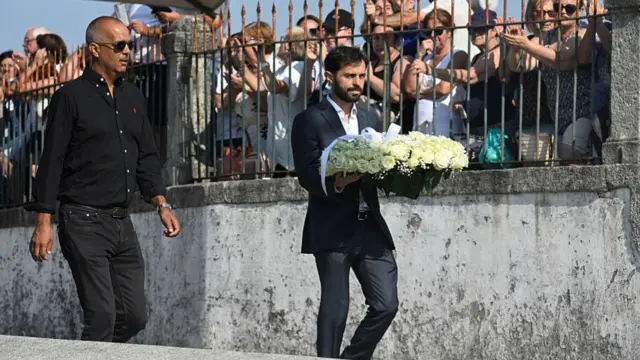 Bernardo Silva carries a white wreath