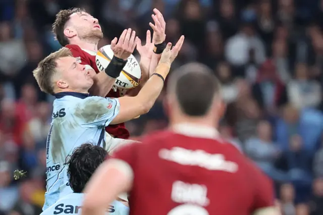 Hugo Keenan (C) and Waratahs' Lawson Creighton (L) fight for the high bal