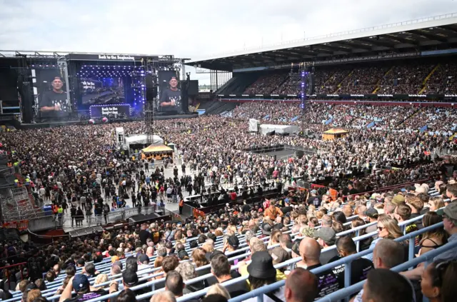 The stage in the background with the crowd in front of it.