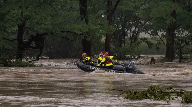 Boerne Search and Rescue teams navigate upstream in an inflatable boat on the flooded Guadalupe River