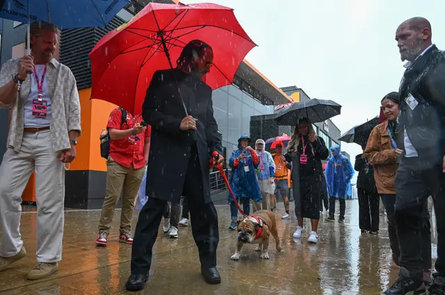 Lewis Hamilton walks Roscoe into the paddock